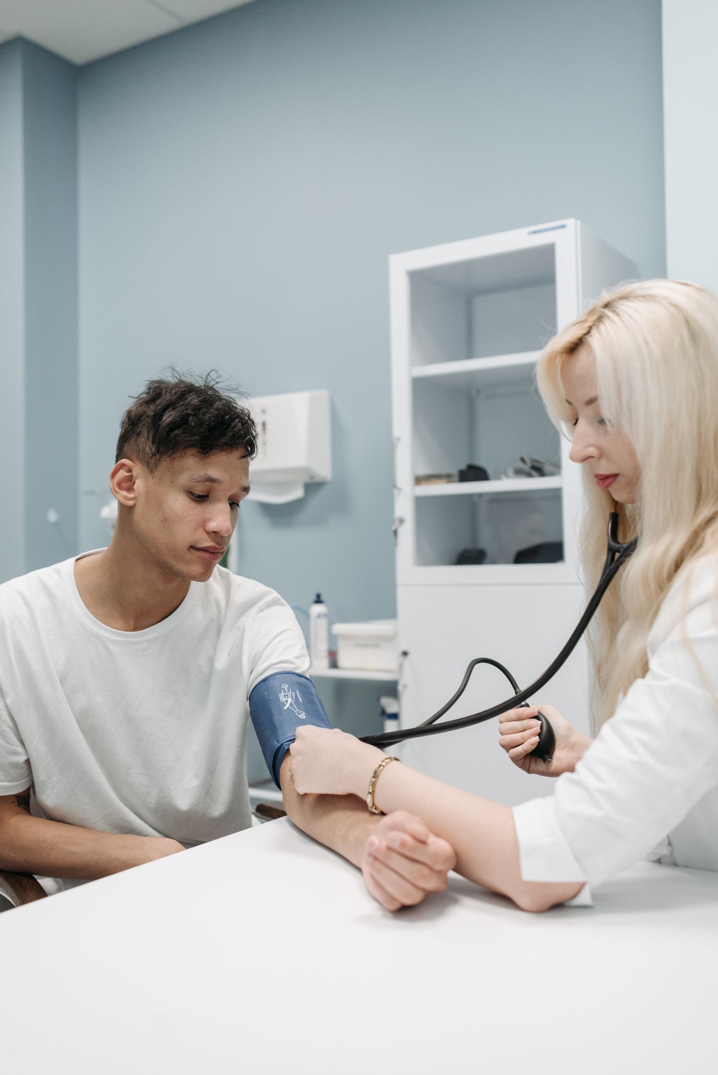 Médica medindo a pressão arterial de um paciente no consultório